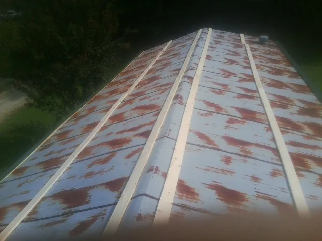 Rusted metal roof panels with new wood purlins before replacement — Storm Damage Roof Repair in West Creek by Roofing Brothers