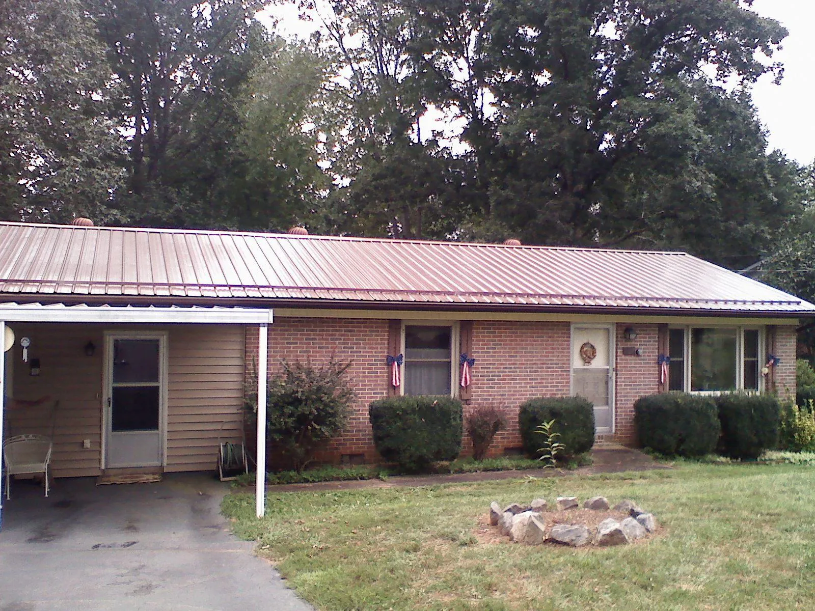 Bronze metal roof and carport on a brick ranch home — Roof Repair work by our crew in West Creek